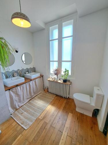 une salle de bain avec deux lavabos et un WC et une fenêtre dans l'établissement Charming house with pool, near metro, à Lyon