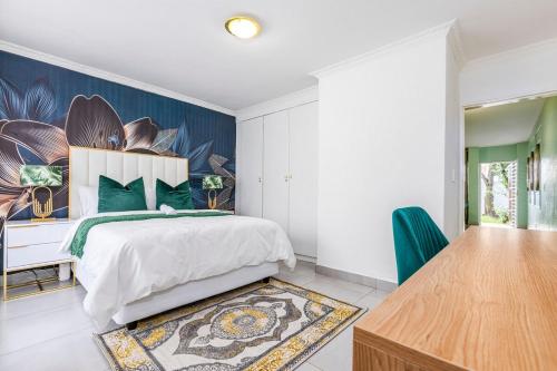 a bedroom with a bed and a desk and a table at II St Tropez Sandton Luxury Suites in Johannesburg
