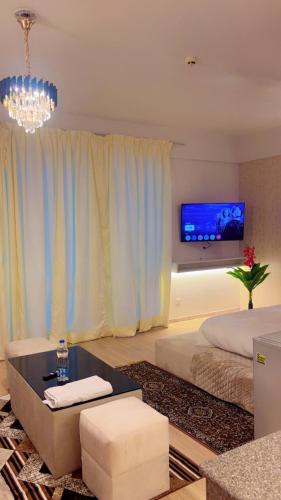 a living room with a bed and a tv at The Royal Suites Gomti Nagar Lucknow in Lucknow