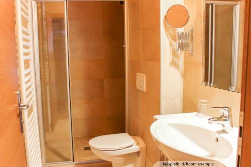 a bathroom with a shower and a toilet and a sink at Sporthotel Shanti in Sankt Anton am Arlberg