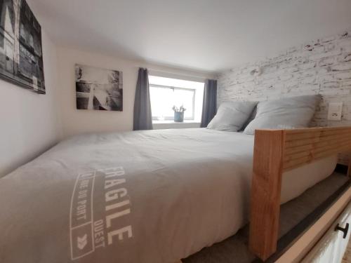 a bedroom with a large bed with a brick wall at Le Petit Saint-Georges, centre historique in Villefranche-de-Rouergue