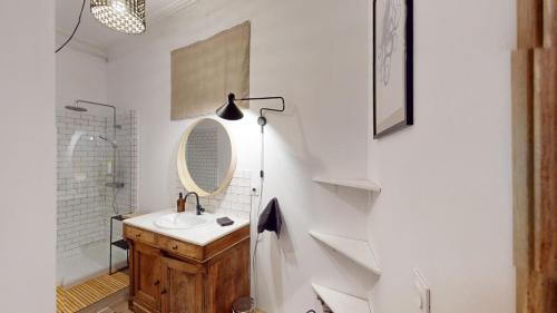 une salle de bain avec un lavabo et un miroir dans l'établissement Mas Saint Côme - Superbe appartement avec mezzanine, à Montpellier