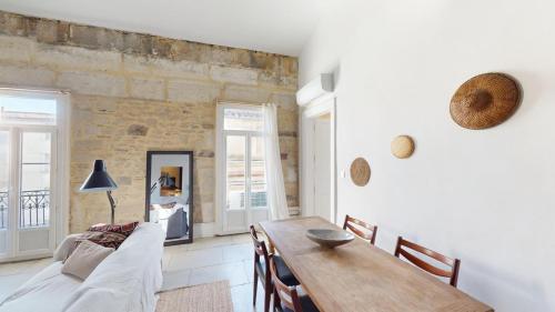 un salon avec une table et un canapé dans l'établissement Mas Saint Côme - Superbe appartement avec mezzanine, à Montpellier