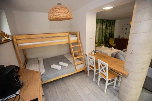 a room with bunk beds and a table and a desk at Hacjenda in Boszkowo-Letnisko
