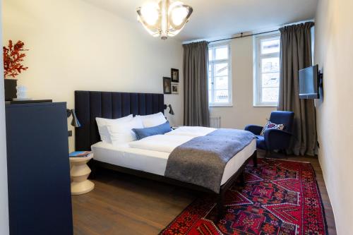 a bedroom with a large bed and a rug at Goldenstern Townhouse in Bolzano