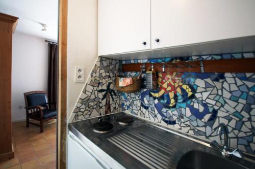 a kitchen with a counter top with a mosaic tile wall at Villa Sainte-Claire maison avec studio in Hyères