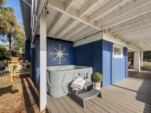 a blue house with a bath tub on a deck at Serenity at the Sea in Tybee Island