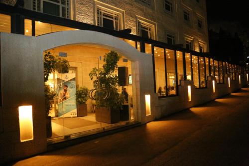 a store front with lights and potted plants on a street at Holyland Hotel Amman in Amman