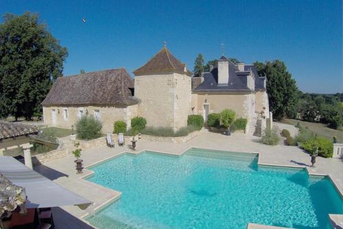 a large swimming pool in front of a house at Domaine de la Rocque in Liorac