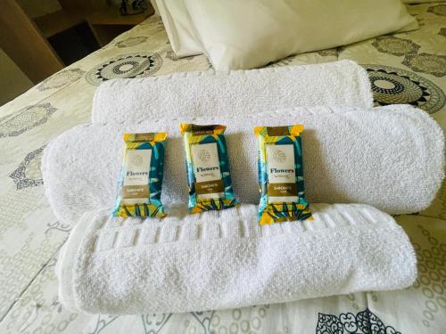 two towels on a bed with three bottles of soap at Zermatt Hotel in Gramado