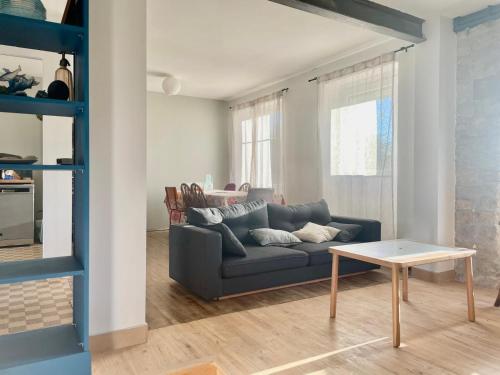 L'Authentik في Gouesnach: غرفة معيشة مع أريكة زرقاء وطاولة