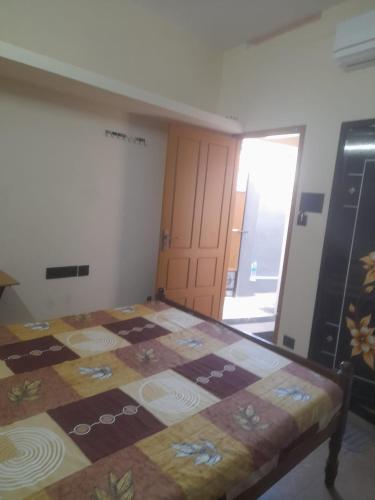 a room with a bed with a quilt on it at AnanthaSayanam Homestay Near Sri Padmanabha Swamy Temple in Trivandrum