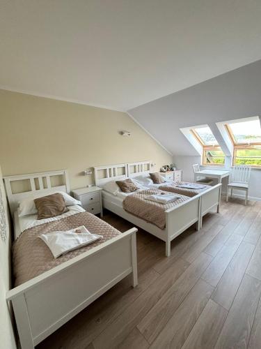 a bedroom with two beds and a table and chairs at Jaśminowe Ogrody in Szczyrk