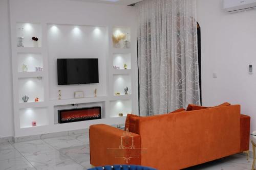 a living room with a fireplace and a tv at Les Jardins de René Hébergements in Yaoundé