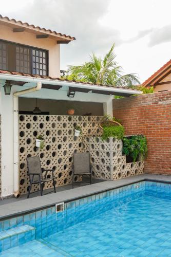 a swimming pool with two chairs next to a house at Chairu Eco Hotel in Santa Cruz de la Sierra