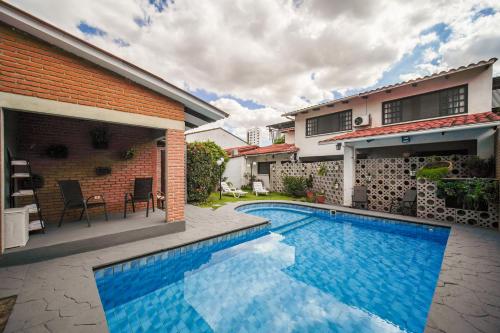 a swimming pool in front of a house at Chairu Eco Hotel in Santa Cruz de la Sierra