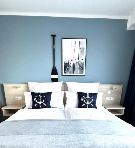 a bedroom with a large bed with blue walls at Apartmenthaus Hohenfels in Helgoland