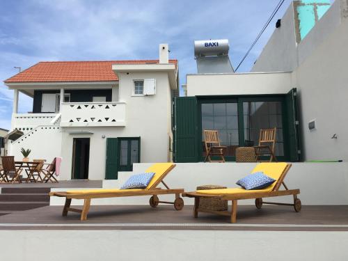 two yellow lounge chairs on the roof of a house at Oporto SurfLodge in Cortegaça