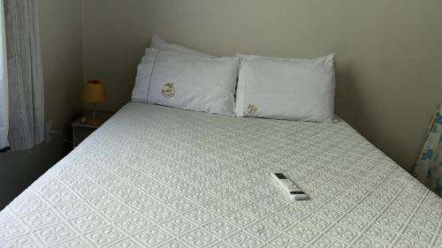 a bed with a cell phone sitting on top of it at Casa Riqueza da terra in Lucas do Rio Verde