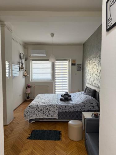 a bedroom with a bed and a couch at Loli apartman in Kraljevo