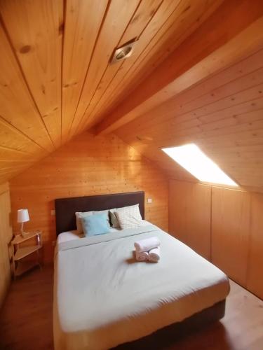 a bed in a room with a wooden ceiling at Oporto SurfLodge in Cortegaça