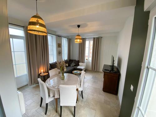 un salon avec une table et un canapé dans l'établissement Maison 2 chambres avec parking et jardin, à Noyon