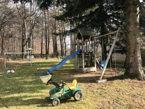 a playground with a green toy car next to a tree at Blockhaus Chalet mit beheizbarem Badefass und Infrarotsauna auf der Terrasse in Oberschützen