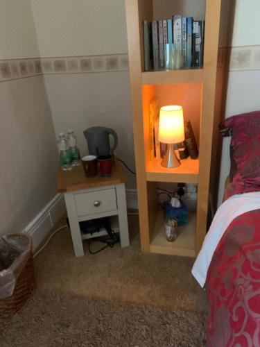 a bedroom with a bed with a lamp and a book shelf at Low Houses Hadrians Wall in Stagshaw Bank