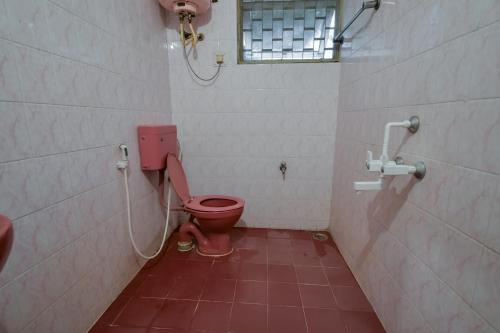 a bathroom with a pink toilet and a window at Snore Summore, Hostel in Koramangala in Bengaluru