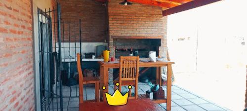 a kitchen with a wooden table and a yellow chair at Casa quincho SHADDAI in Paso de la Patria