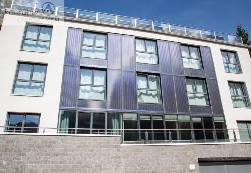an office building with a purple and white facade at Sporthotel Shanti in Sankt Anton am Arlberg