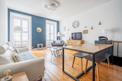 un salon avec un canapé et une table dans l'établissement Appartement bourgeois hyper centre-ville de Bordeaux, à Bordeaux