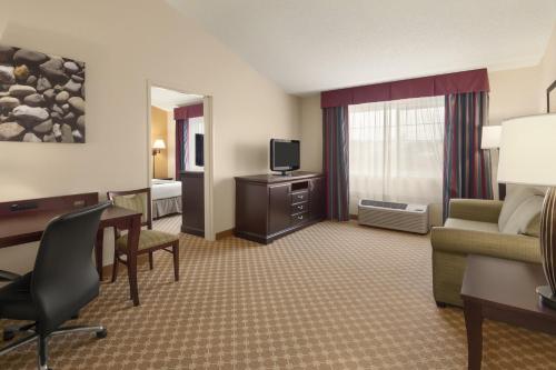 a hotel room with a desk and a living room at Country Inn & Suites by Radisson, Sioux Falls, SD in Sioux Falls