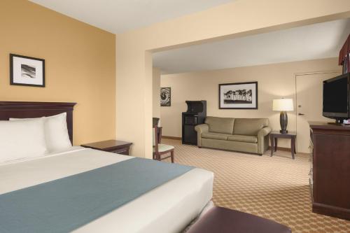 a hotel room with a bed and a couch at Country Inn & Suites by Radisson, Sioux Falls, SD in Sioux Falls