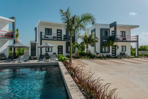a building with a swimming pool in front of a house at Genesis Residences in Meads Bay