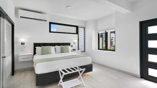 a white bedroom with a large bed and a window at Genesis Residences in Meads Bay