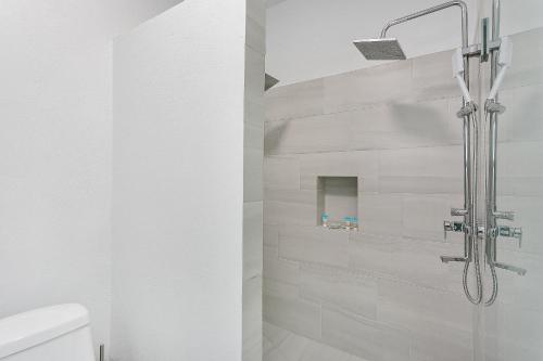 a shower in a white bathroom with white tiles at Genesis Residences in Meads Bay