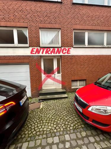 a red car parked in front of a brick building at sleepWELL-Horstmar Zentral & Kirchennah in Horstmar