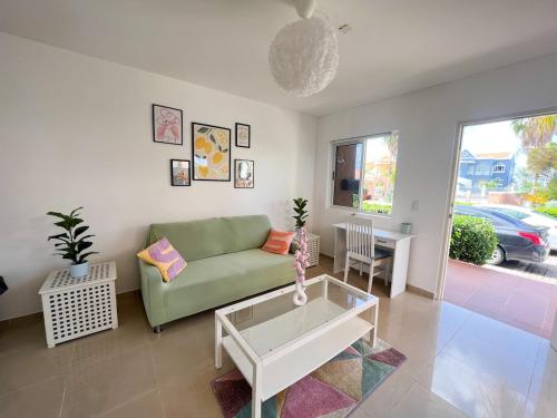 a living room with a green couch and a table at Caribbean Beach Resort 3, Piscadera - Casa D'Oro in Sint Michiel