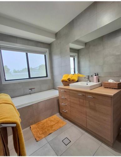 a bathroom with a sink and a bath tub at Kennedy House Euroa PERFECT FOR SHORT TERM STAYS in Euroa