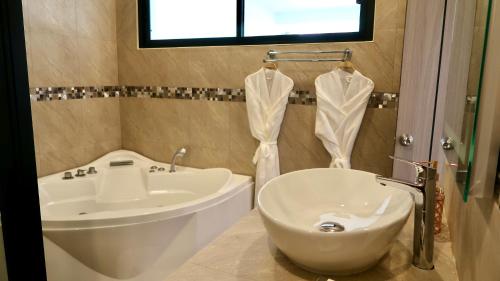 a bathroom with a sink and a tub and a toilet at Jasmine Village in Rawai Beach