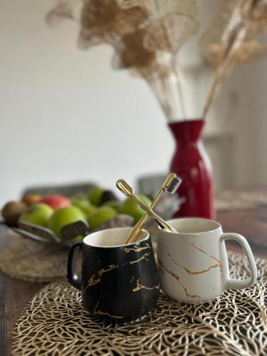 two coffee cups on a table with a bowl of fruit at Villa Perla del Sole in Baiardo