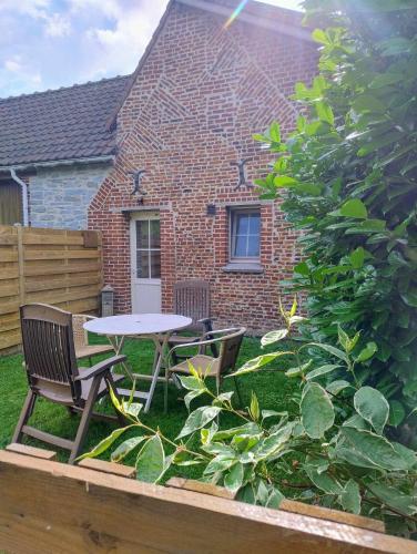 a patio with a table and chairs in a yard at La Maisonnette - 2 chambres, parking, jardinet & calme in Tournai