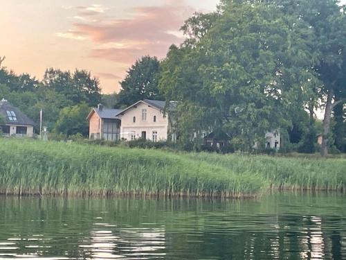 a house on a hill next to a body of water at Kleines Fährhaus in Ulsnis