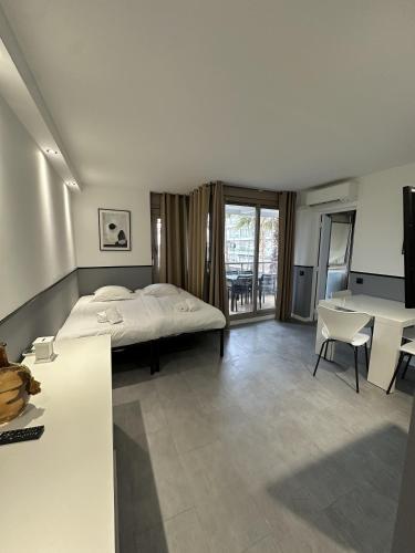une chambre avec un lit, une table et des chaises dans l'établissement Résidence Graziella Appartement 222, à Juan-les-Pins