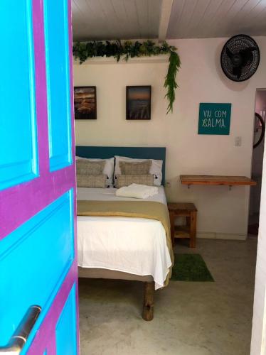a bedroom with a bed and a sign on the wall at Suíte Colorida em Cabo Frio in Cabo Frio