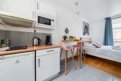 Il comprend une cuisine et un salon avec un lit et une table. dans l'établissement 403 - Charmant studio jardins des plantes -Paris 5 - FLAT-GUEST, à Paris