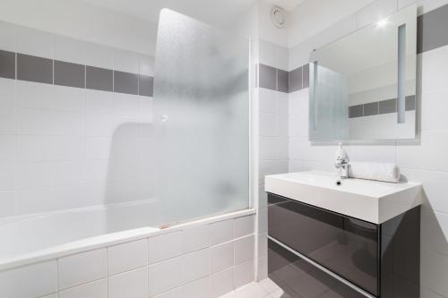 une salle de bain blanche avec un lavabo et un miroir dans l'établissement 403 - Charmant studio jardins des plantes -Paris 5 - FLAT-GUEST, à Paris