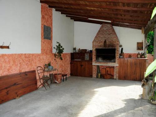 a large room with a brick fireplace in a house at Hermoso Chalet 6 personas a cuadras del Mar in Miramar