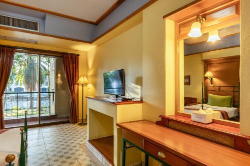 a hotel room with a large mirror and a bed at Pung-Waan Resort & Spa in Kanchanaburi
